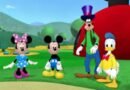 A 3D animated scene from Mickey Mouse Clubhouse showing the main characters on a green hill in front of the iconic red clubhouse. The show aired from 2006 to 2016 and was broadcast across Latin America including on Spanish-language platforms from 2014 to 2018.